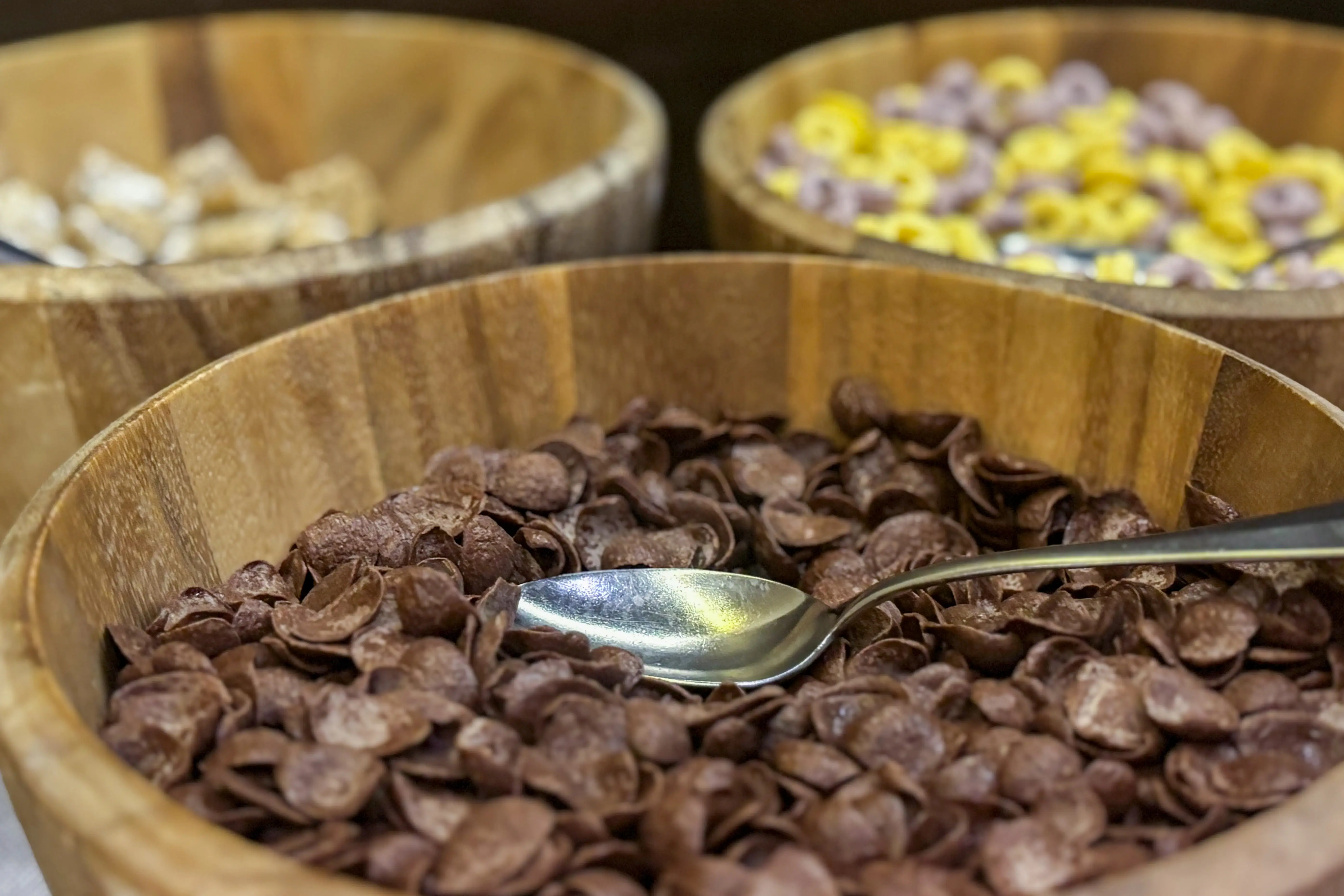 A bowl of cornflakes with a spoon in the background Other types of cornflakes