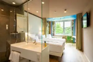 Double room nature A room with a glass shower and two beds.