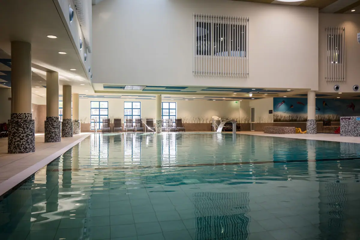 Large indoor pool with clear water and modern architecture.