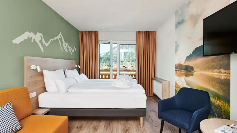 Rooms & Suites A room with a bed and a chair.