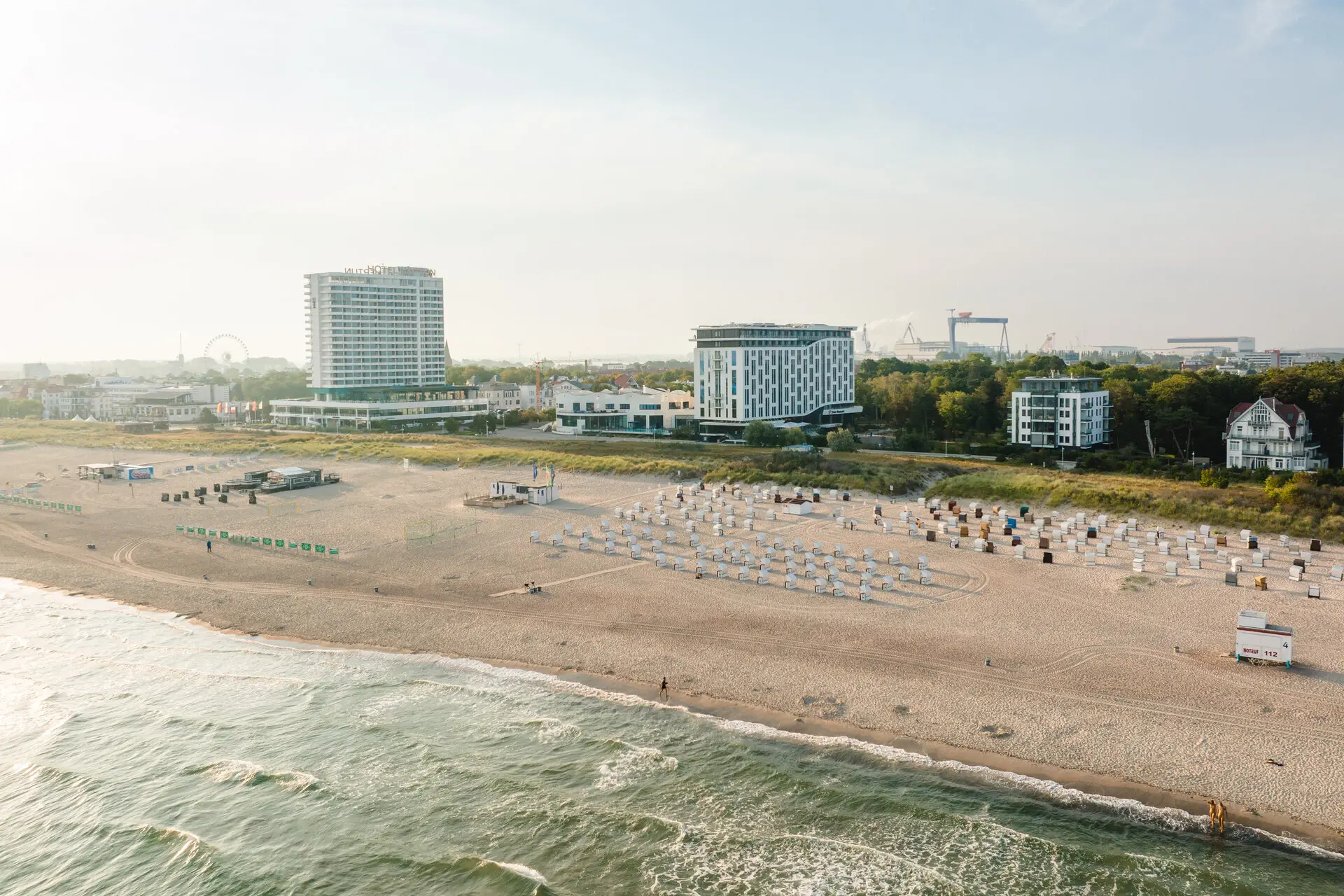 Beach filled with chairs and umbrellas under a cloudy sky.