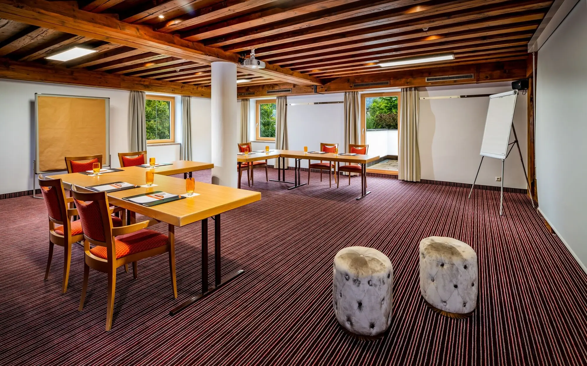 Meeting room with tables, chairs and glasses of water on the tables.