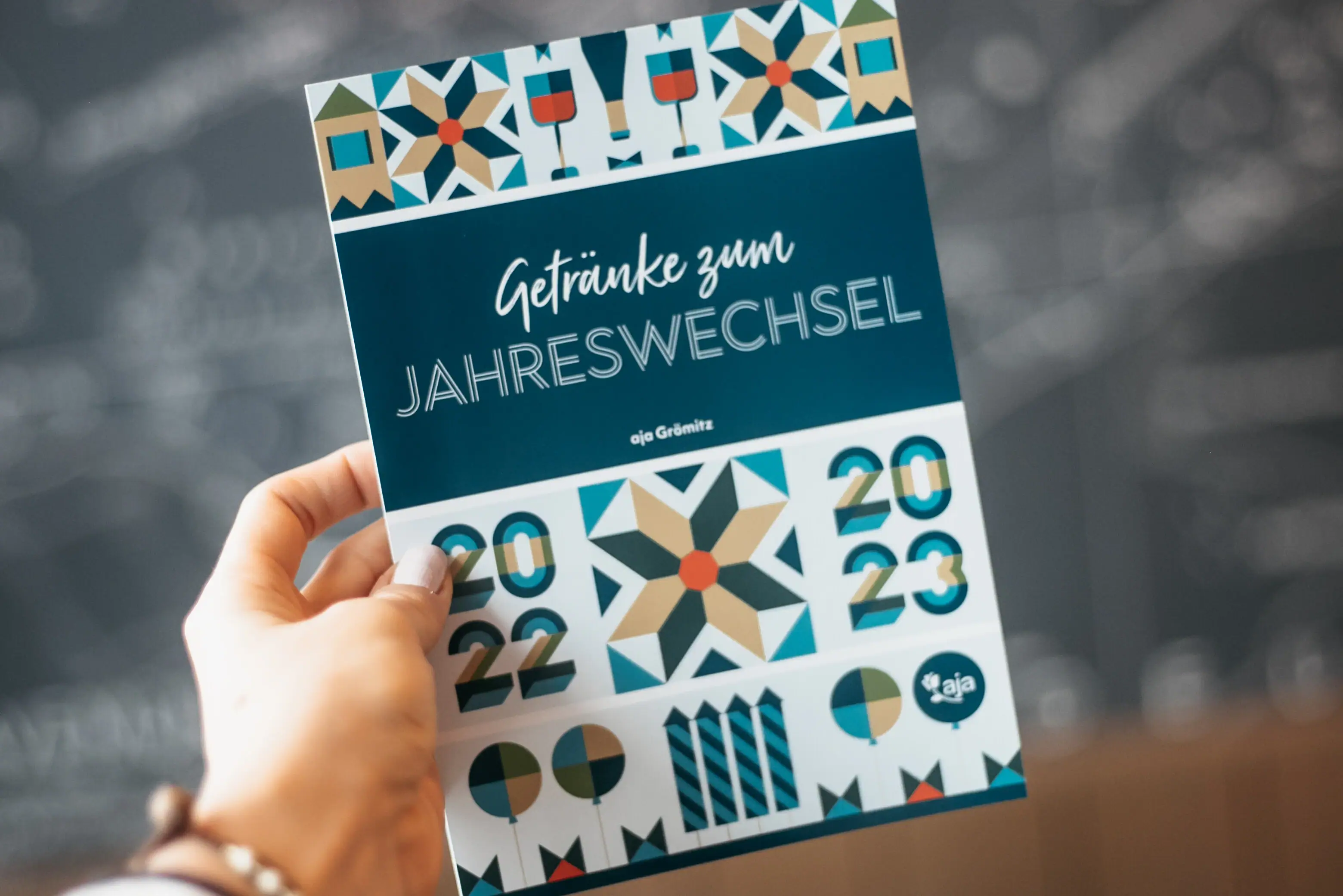 One hand holds a programme booklet for the New Year's Eve party.