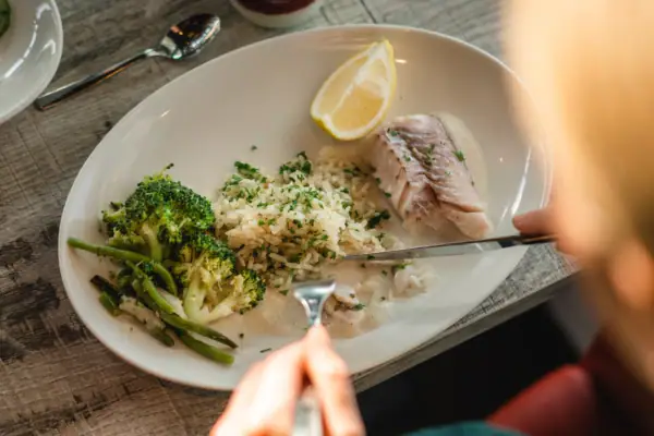Person eats from a plate of food.
