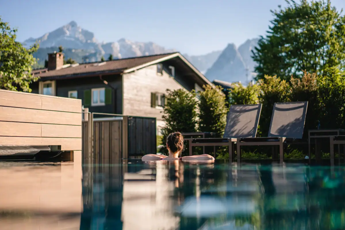 Outdoor pool A person in the pool with trees in the background.