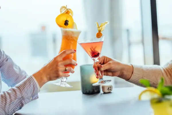 Cocktails A pair of hands holds glasses with drinks.