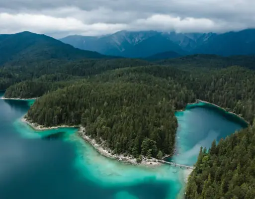 Eibsee bird's eye view A body of water with trees and mountains in the background.