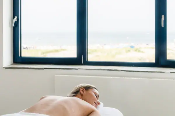 A woman lies on a massage table.