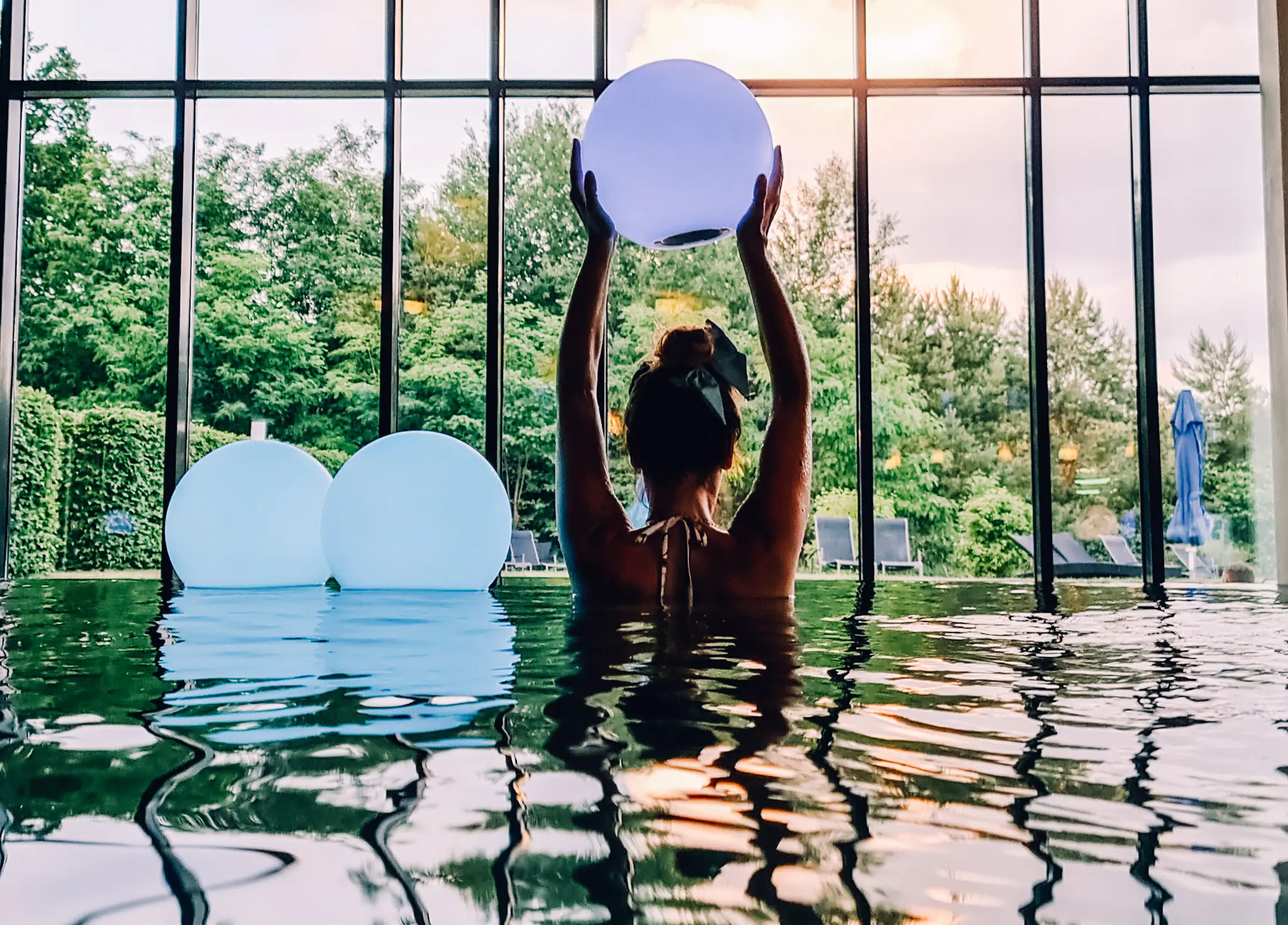 Indoor pool at Bad Saarow A woman in the pool is holding a ball.