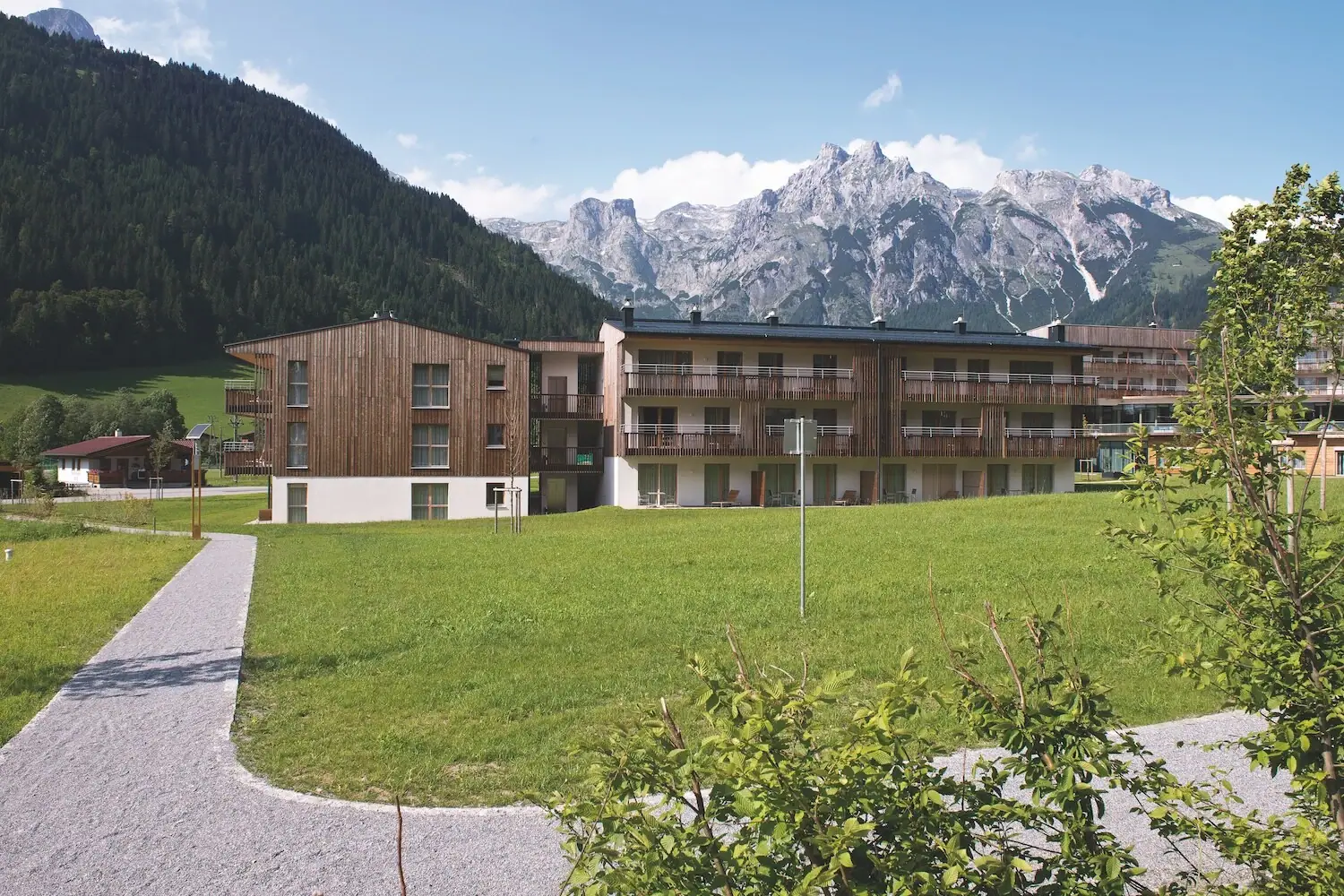 A building with a lawn and mountains in the background.