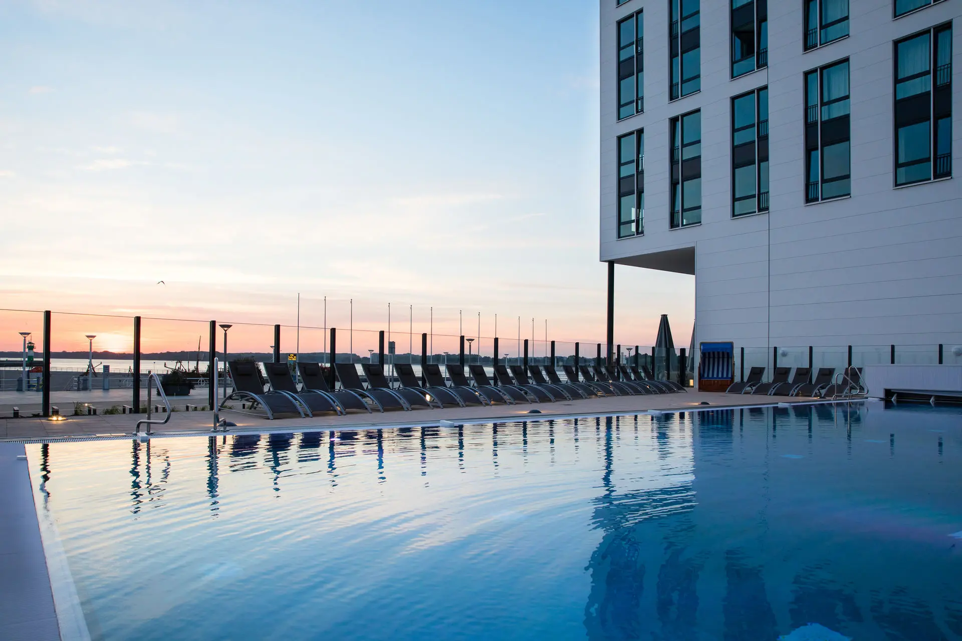 Swimming pool with sun loungers and a building in the background