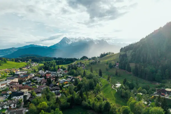 A town in a valley, surrounded by trees and mountains.