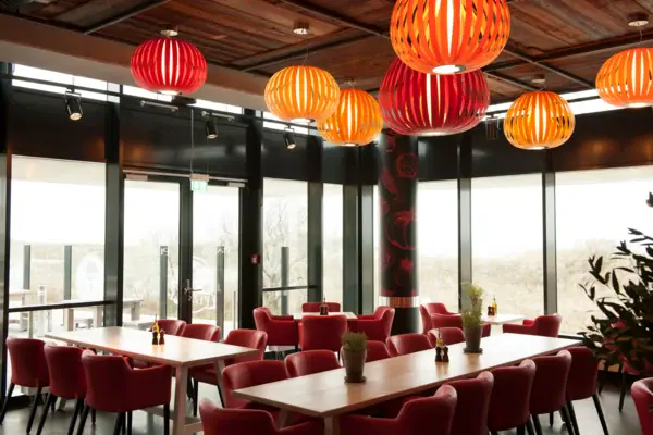 A room with tables, chairs and red lanterns.