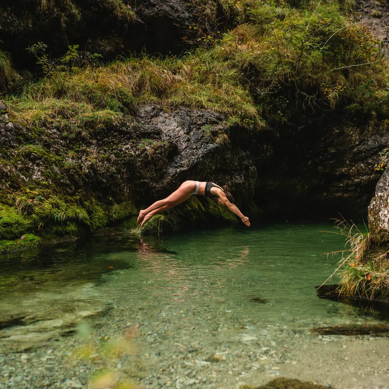 A person dives into a body of water.