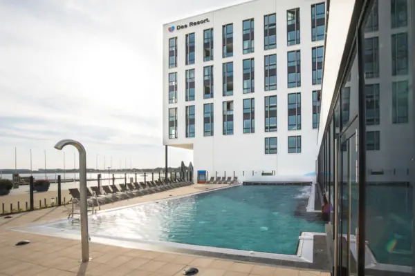 A swimming pool next to a building, outdoors.