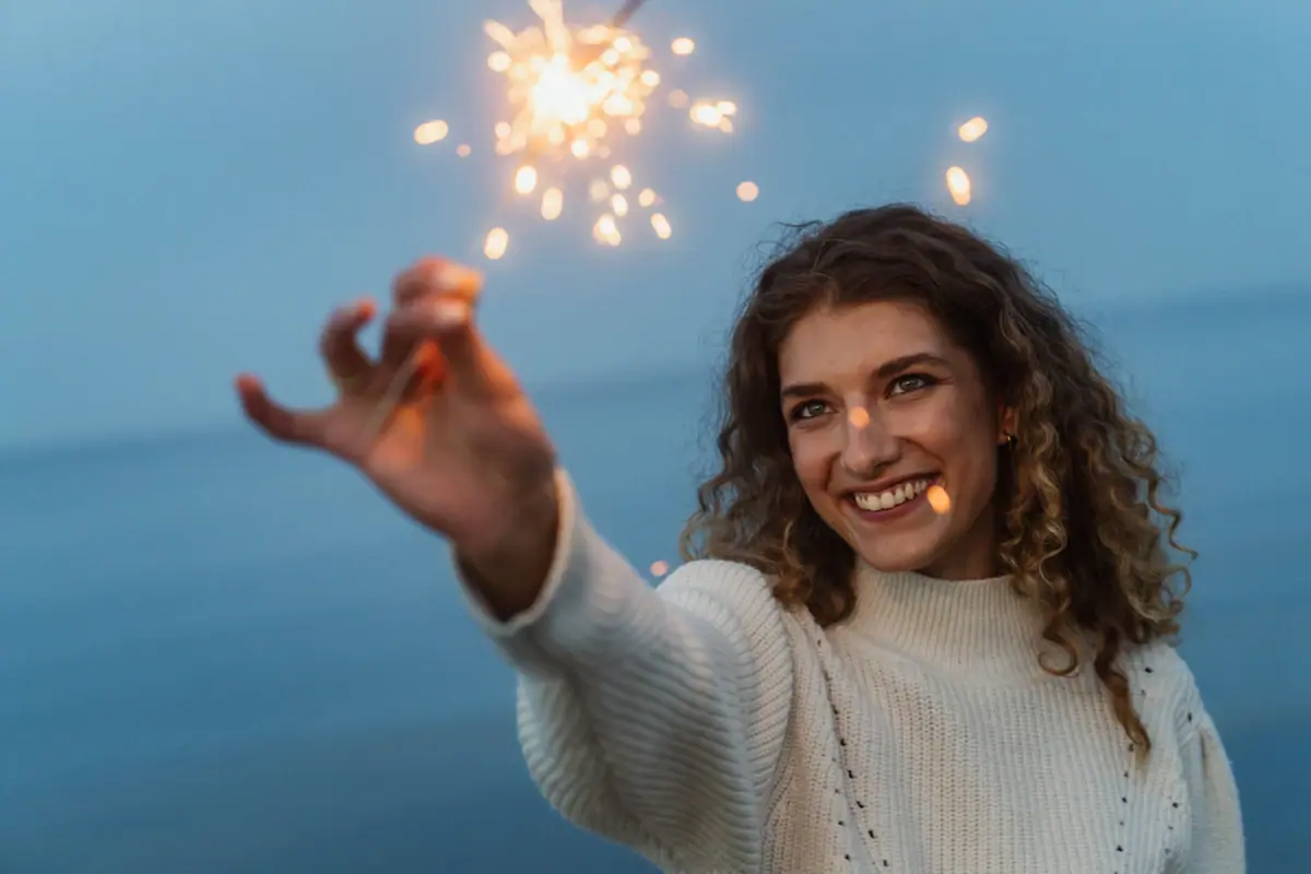 A woman is holding a sparkler.